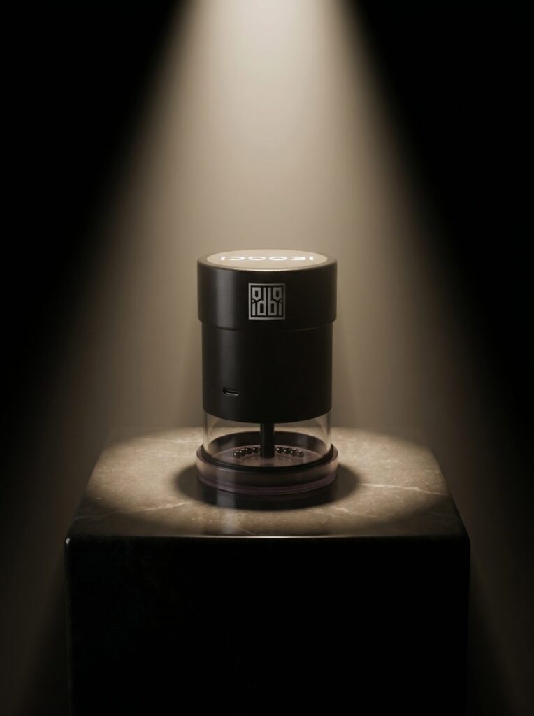 idoobi electric herb grinder on a marble block, black body with a clear grinding chamber