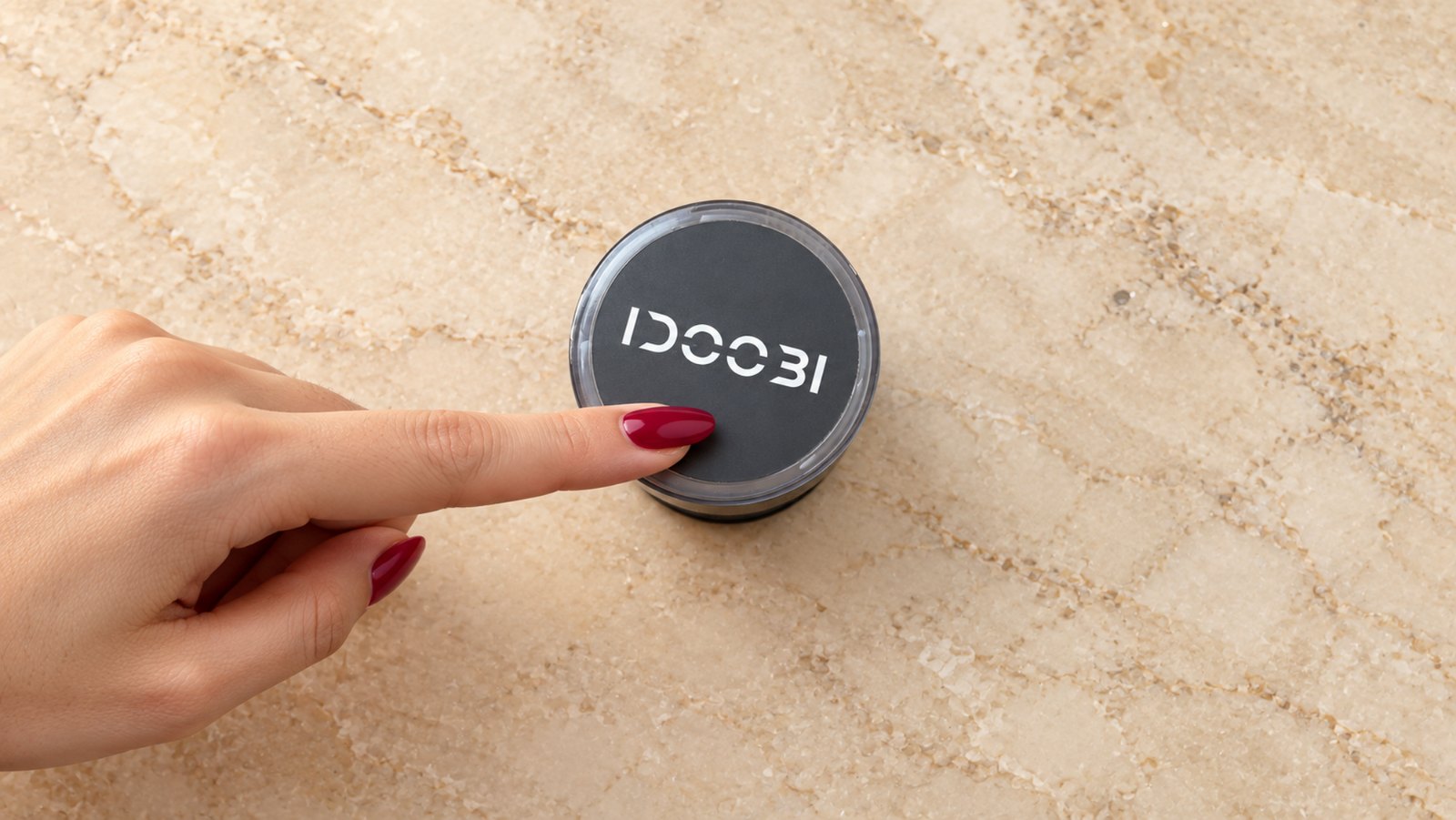 One finger pressing the top of the idoobi electric herb grinder to grind, no twisting